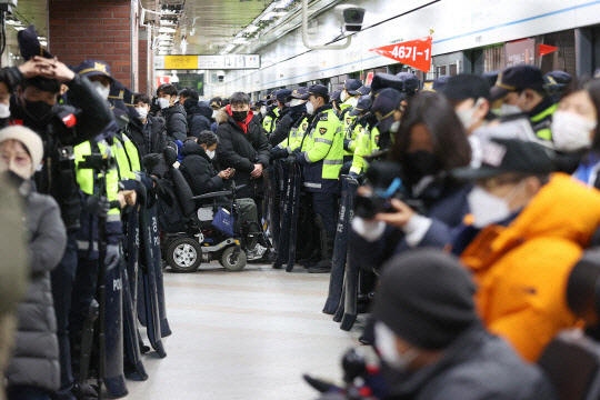 전국장애인차별철폐연대(전장연) 회원들이 지난 1월2일 서울 지하철 4호선 삼각지역 승강장에서 지하철 탑승을 시도하는 가운데 경찰이 배치돼 있는 모습. 연합뉴스ㅈ